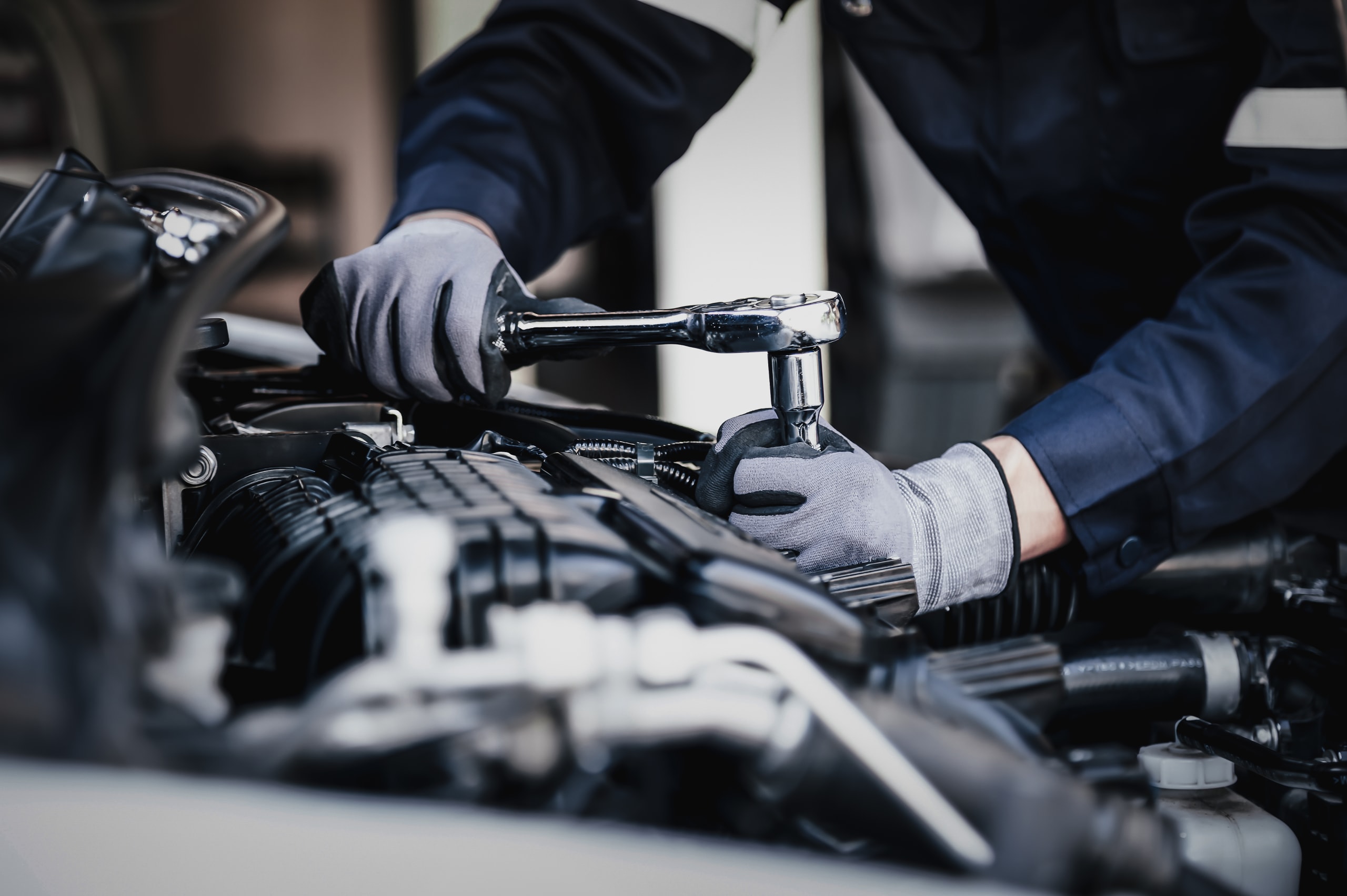 Mechanic using wrench on car engine.